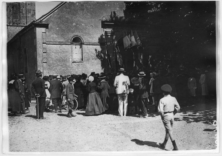 La foule devant l'église, dont les portes sont pavoisées