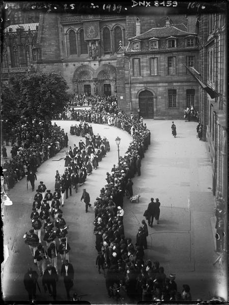 Défilé folklorique et fanfare, façade sud de la cathédrale et portail de l'horloge astronomique en arrière-plan