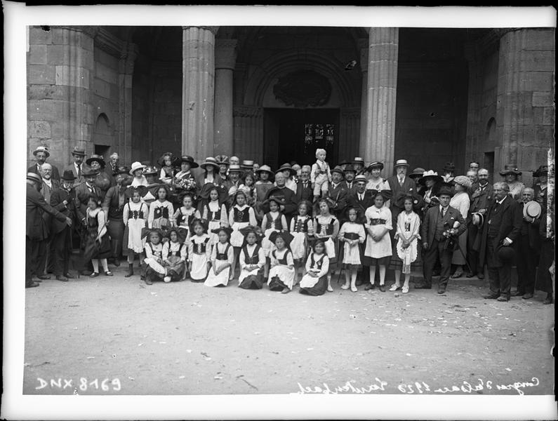 Congrès de 1920, portrait collectif : congressistes et femmes en costume traditionnel alsacien devant le porche de l'église