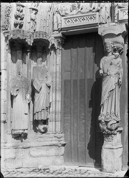 Façade ouest, portail principal, côté gauche : Vierge à l'Enfant au trumeau et piédroit orné de deux statues acéphales