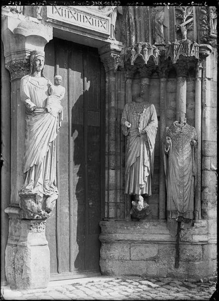 Façade ouest, portail principal, côté droit : Vierge à l'Enfant au trumeau et piédroit orné de deux statues acéphales