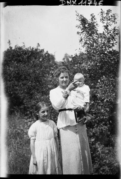 Portrait collectif : femme portant un bébé dans ses bras et petite fille