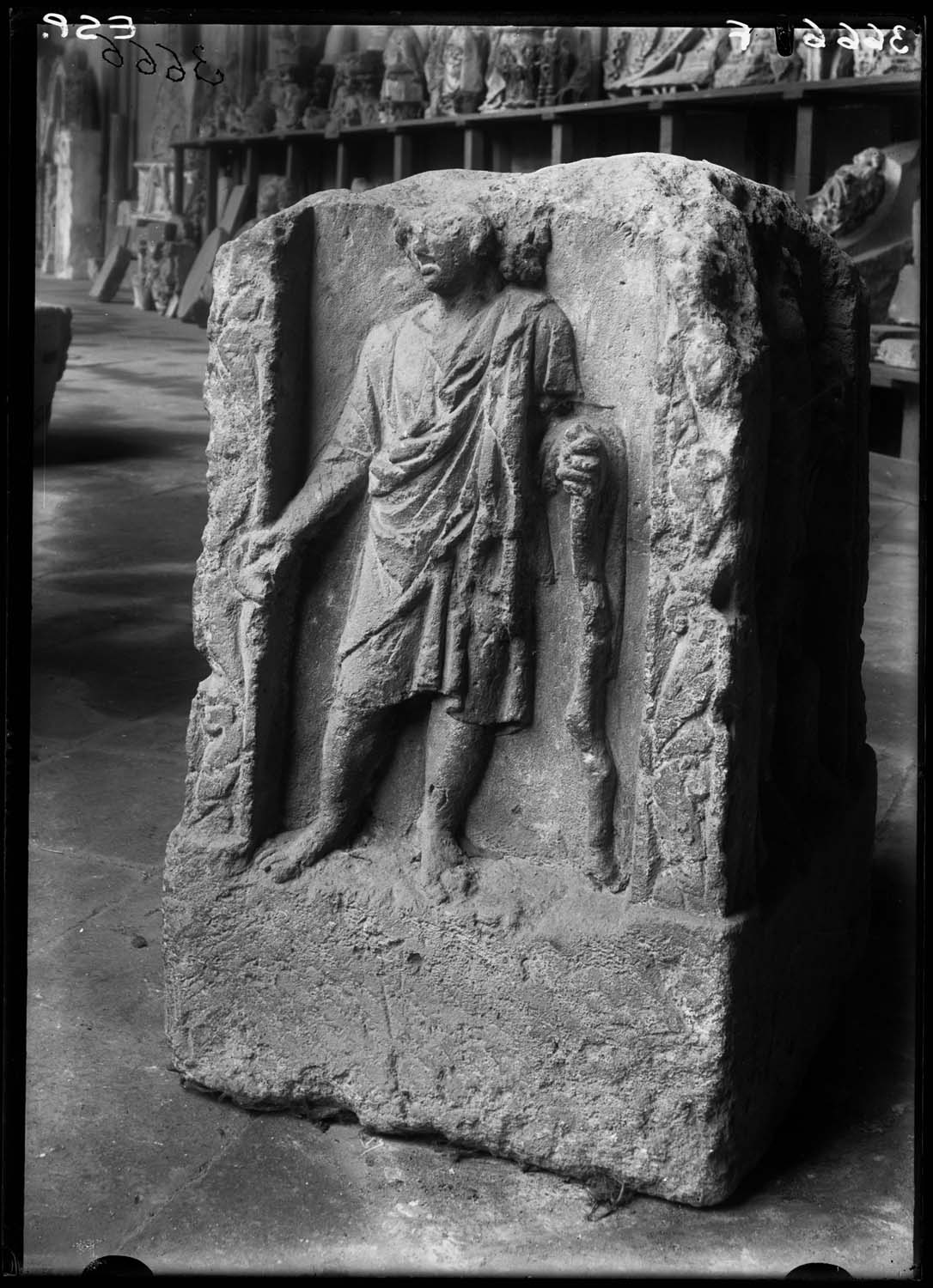 Bolc sculpté avec un dieu à deux visages apparents, l'un imberbe, l'autre barbu