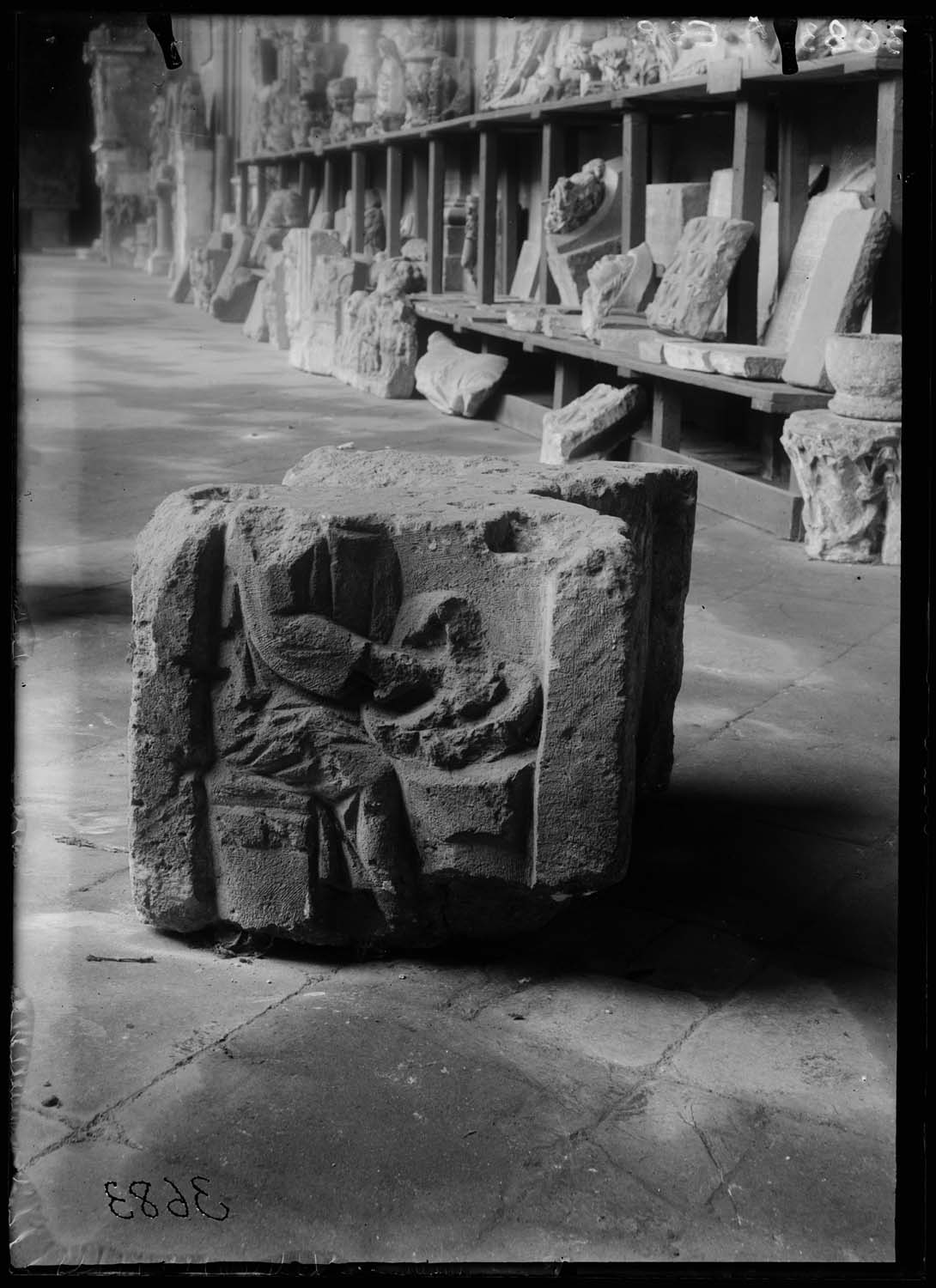 Bloc sculpté avec un homme assis pilant des denrées (?) dans un mortier