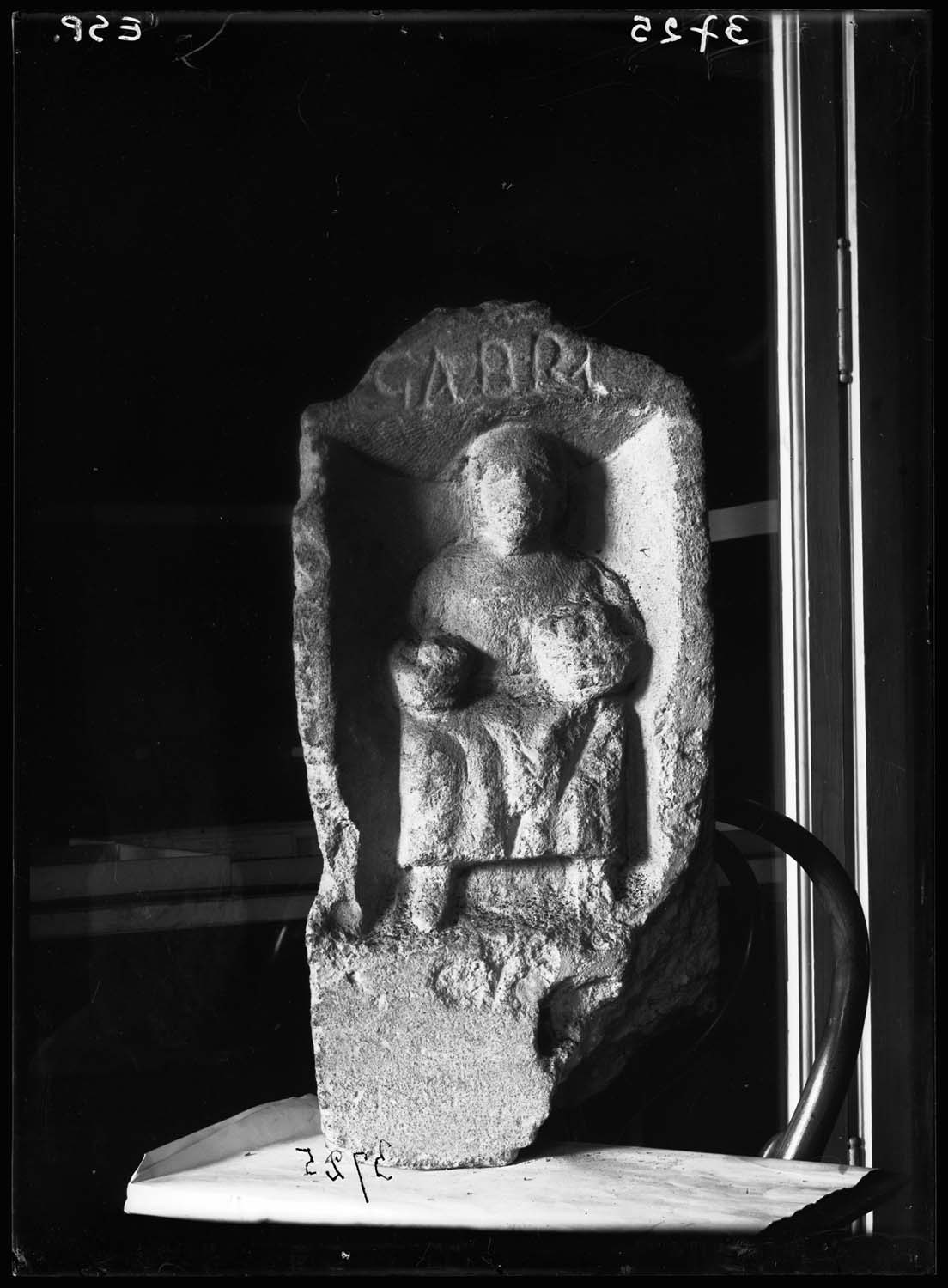 Stèle avec une femme assise tenant un gobelet et une corbeille de fruits