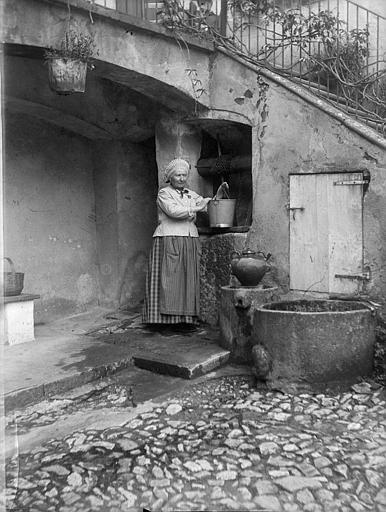 'Au puits chez ma belle-mère ; Jardin de Saint-Antonin ; [Une femme puisant de l'eau]'