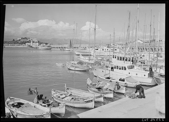 Le port : la jetée, le phare. Pêcheur rangeant les filets, au fond le Fort-Carré