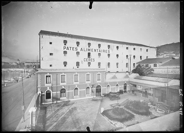 Vue sur cour des bâtiments, sur le batiment central publicité 'Pates alimentaires Ceres' : bâtiment perpendiculaire : service de l'eau potable aux navires.