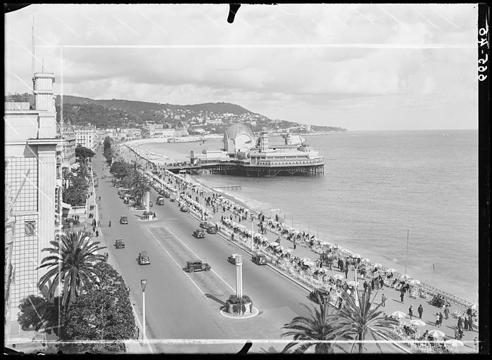 Vue en oblique, promenade du front de mer au premier plan. Le Casino au fond