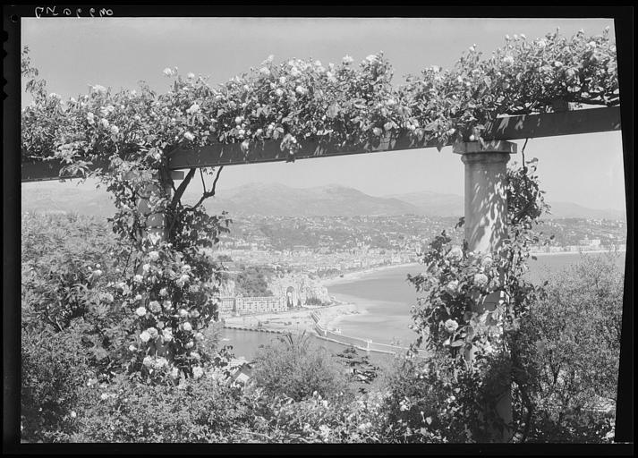 Vue générale sur le port depuis une terrasse avec pergola, le Monument aux Morts