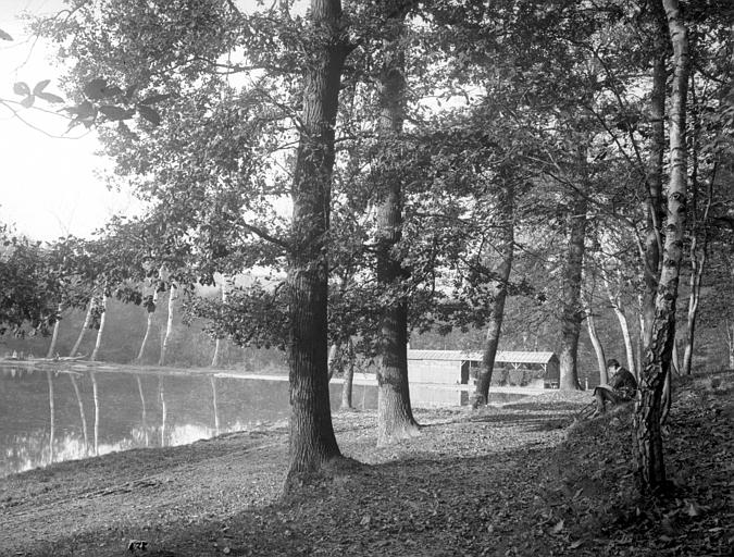 Etang, baraque 'A l'étang de Trivaux, au rendez-vous des artistes et des pêcheurs', arbres, homme avec bicyclette assis sur un talus à droite