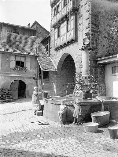 Femme et enfants devant la fontaine