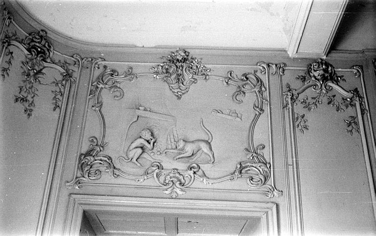 Salon : décor en bas-relief au-dessus d'une porte représentant un singe et un chat