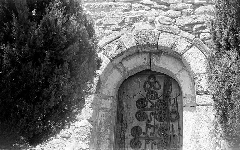 Portail roman de la façade sud avec porte en bois et ferrures