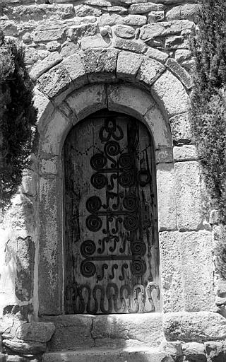 Portail roman de la façade sud avec porte en bois et ferrures