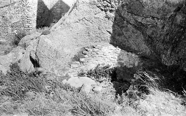 Vestiges de mur contre un rocher