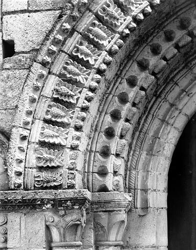 Façade ouest, portail, baie centrale : détail des voussures de gauche