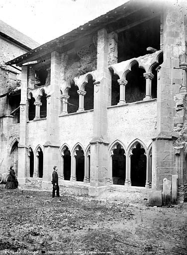 Cloître servant de dépôt : extérieur, homme et femme en pose devant la façade