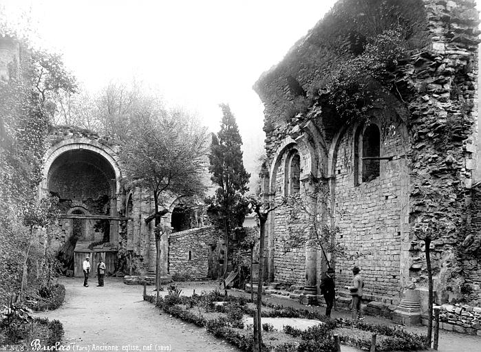 Ancienne église : nef en ruines, réemployée en jardin, deux hommes en pose