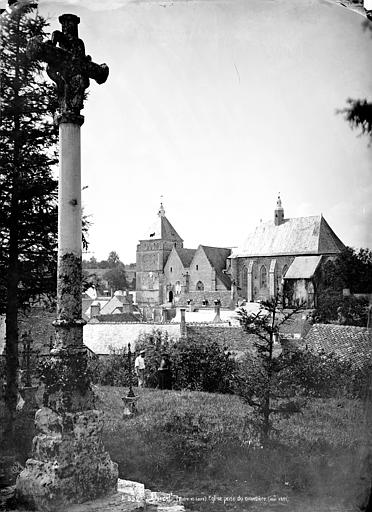 Ensemble, vue prise du cimetière. Le curé et un jardinier en pose dans le cimetière