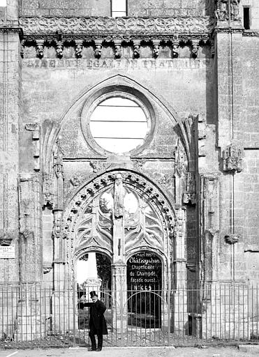 Façade principale en ruine marquée 'Liberté Egalité Fraternité', homme en pose devant