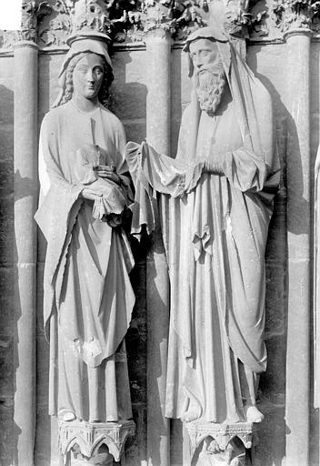 Portail central de la façade ouest. Ebrasement gauche : Groupe de la Présentation au Temple, statues de la Vierge à l'Enfant et de saint Siméon