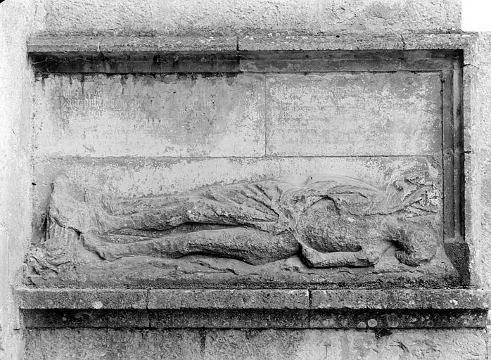 Bas-relief sculpté dans le contrefort, à droite du portail de la façade nord : Gisant