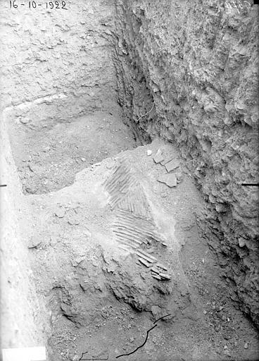 Fouilles dans le jardin montrant un vestige de foyer de cheminée, en tuiles posées de champ