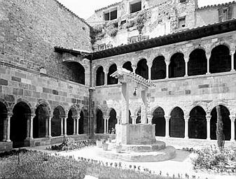 Cloître vu d'angle, vieux puits et bâtiments