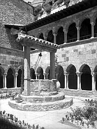 Cloître vu d'angle, vieux puits et bâtiments