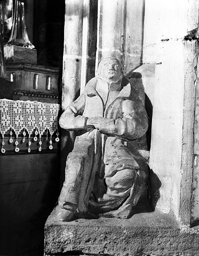 Homme assis sculpté au pied d'un pilier du carré du transept