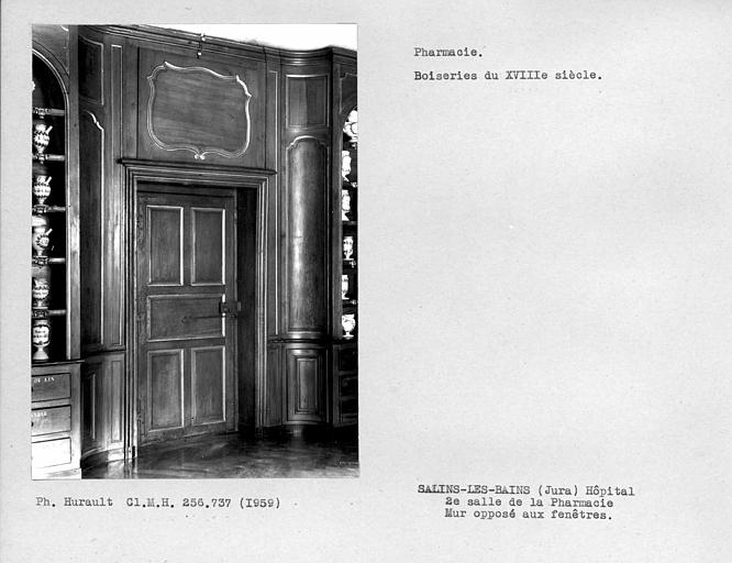 Deuxième salle de la pharmacie, vantail de porte du mur opposé à la fenêtre et boiseries qui l'encadrent