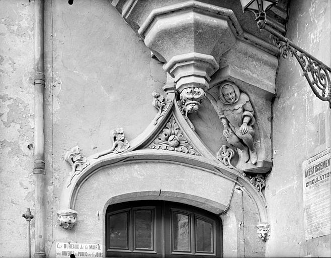 Entrée près du porche, côté intra-muros : fronton de porte, base de la tourelle à encorbellement et corbeau sculpté