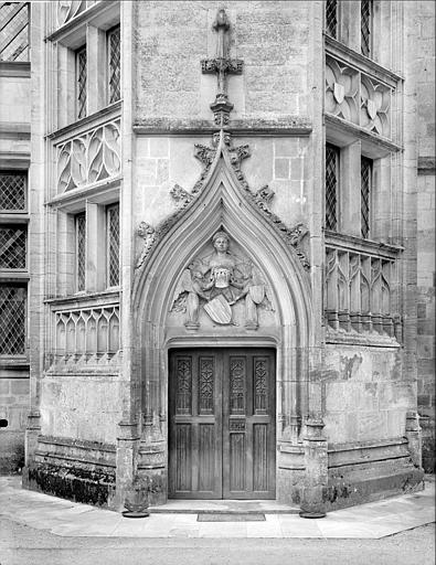 Tour octogonale accolée à la façade du logis (partie gauche). Porte de l'escalier surmontée d'un décor sculpté : deux anges portant des écussons