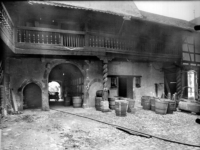 Cour intérieure : porche et galerie avec balustrade en bois