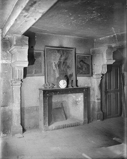 Intérieur d'une salle : cheminée, pendule, tableaux