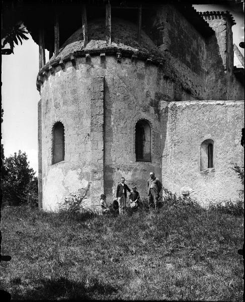 Un homme et trois enfants posant devant l'abside