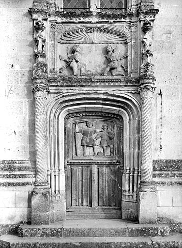 Façade ouest : Porte d'entrée de la tour ornée de deux personnages et surmontée de deux amours