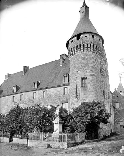 Ensemble sud. Tour d'angle et façade sur rue. Monument aux morts au premier plan