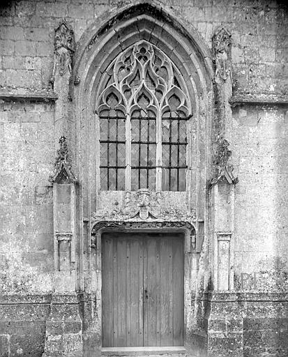 Façade ouest : Portail. Tympan orné d'étoiles. Linteau avec double rinceau que crachent deux serpents