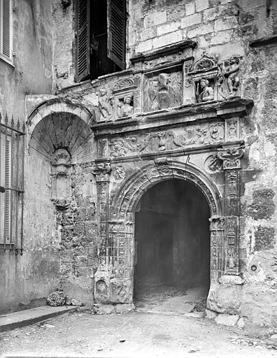 Porte Renaissance sculptée, surmontée de bustes en reliefs. Départ d'une trompe à gauche