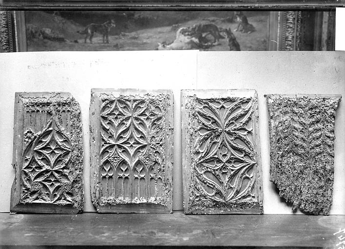 Reliefs (4) : Panneaux sculptés en bois dessinant des motifs flamboyants et provenant d'une ancienne porte de l'église