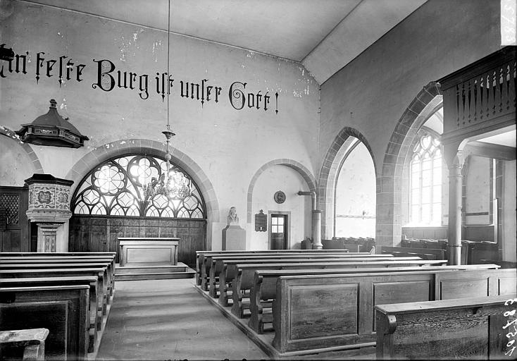 Vue intérieure de la nef et du bas-côté sud, vers l'est. Chaire pastorale. Inscription peinte