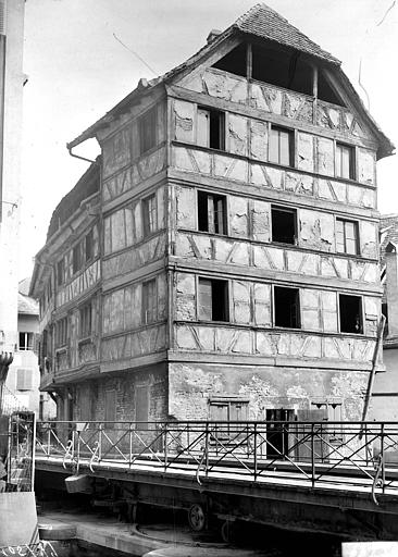 Vue d'ensemble de la maison à pans de bois depuis l'autre rive de l'Ill, avant restauration. Pont