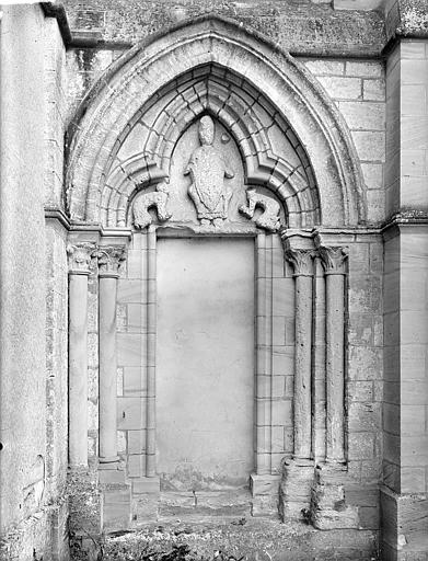 Façade sud, à l'angle du transept et du chevet : Portail muré. Tympan sculpté : Personnages