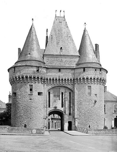 Pavillon carré encadré de deux grosses tours vu depuis l'extérieur de l'enceinte. Pont