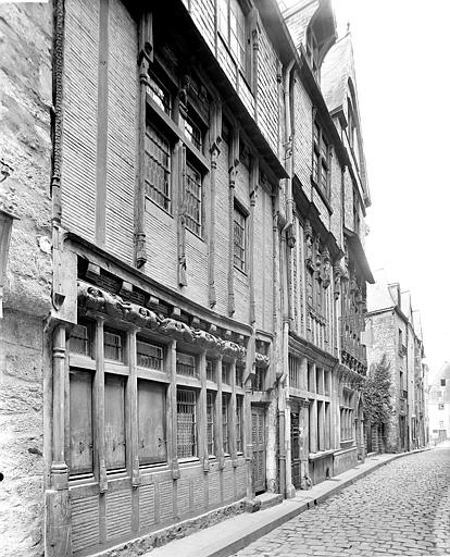 Façade sur rue à pans de bois au premier plan et en pierre de taille à l'arrière-plan