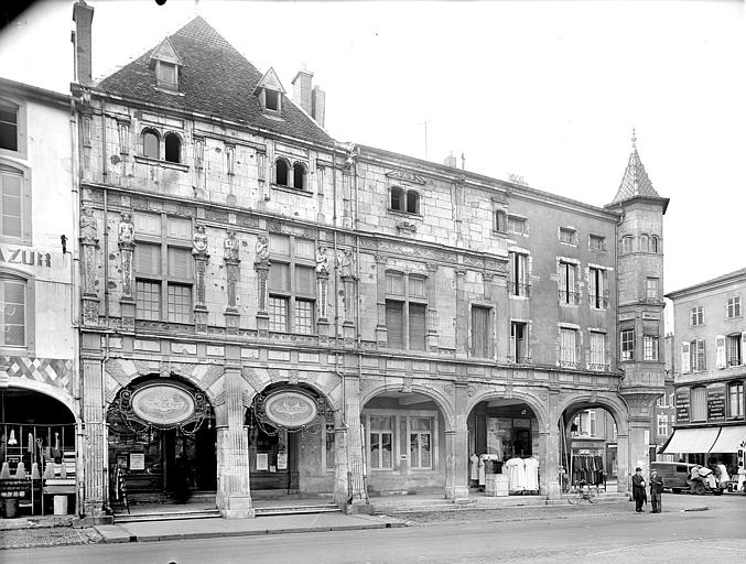 Façade à galerie d'arcades et tourelle, donnant sur la place. Premier étage décoré de bas-reliefs : Termes représentant les sept péchés. Commerces