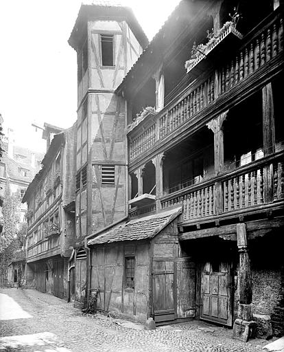 Vue de la cour et d'un bâtiment à galeries. Façade à pans de bois