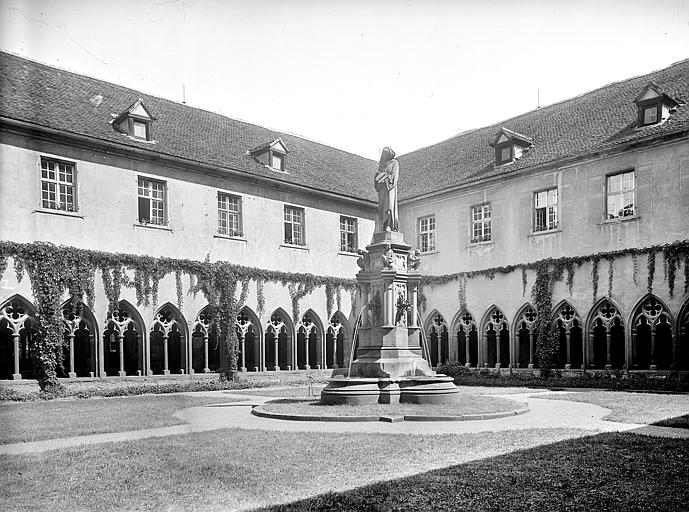 Vue d'ensemble de la cour du cloître avec au centre une fontaine surmontée d'une sculpture de Bartholdi représentant Schongauer et quatre statuettes : un peintre, un graveur, un penseur et un sculpteur